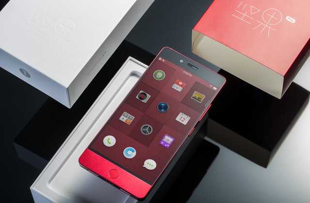 Новый красный телефон, который был куплен в кредит без банка, лежит в белой упаковке