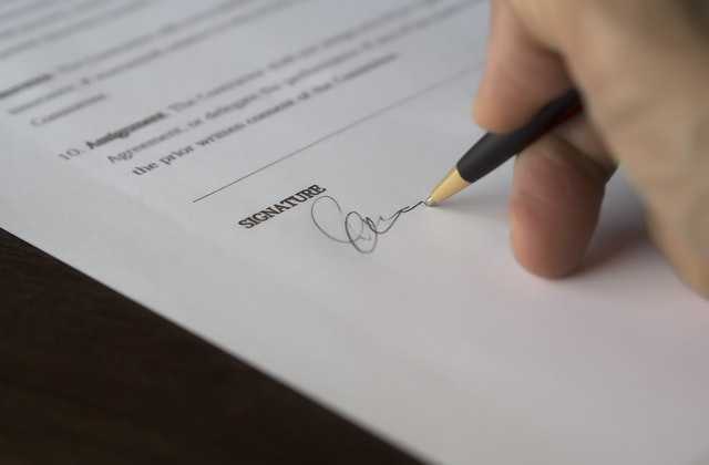a person signs a loan agreement with a pen to get the money he will spend in the Philippines