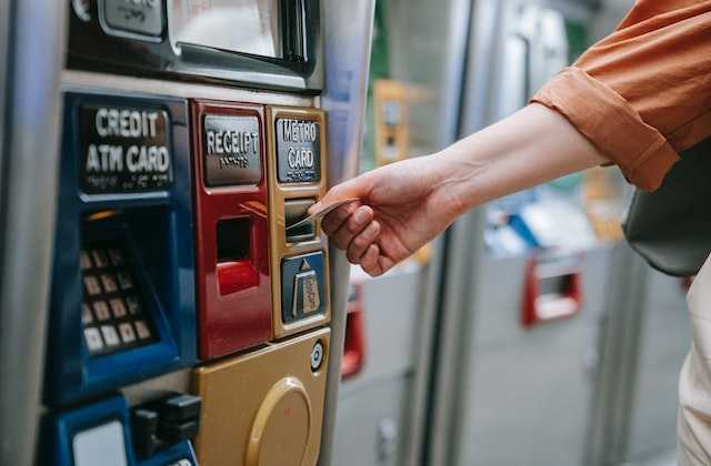 Девушка вставляет в банкомат карту, потому что прочитала статью о том, как снять деньги с банкомата
