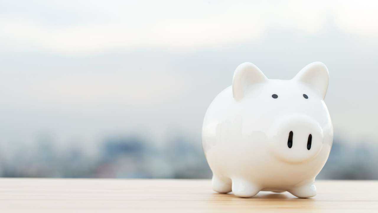 На столе стоит копилка в форме свинки как символ одного из способов сбережения денежных средств